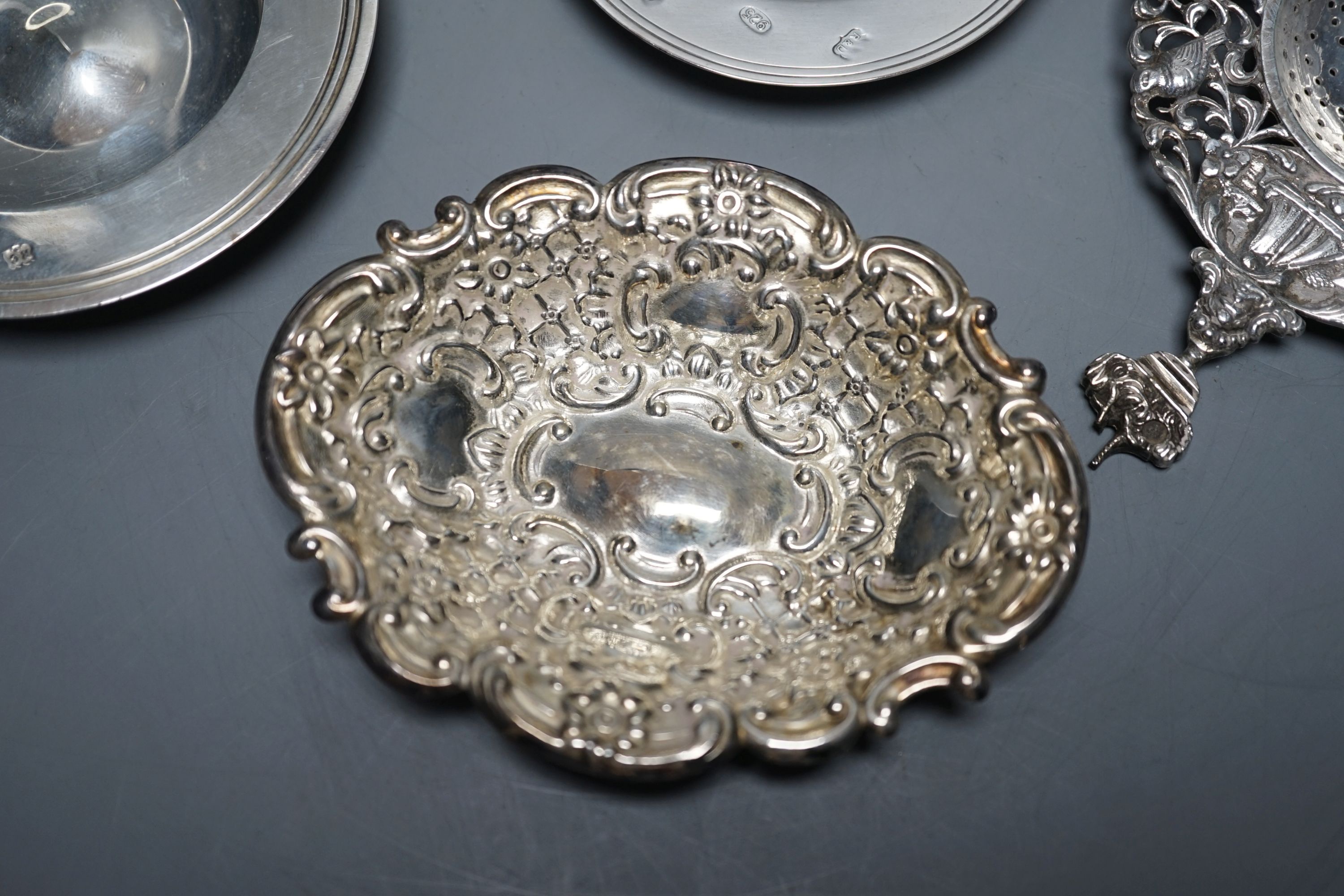 A late Victorian silver mustard, Sheffield, 1895, two small silver armada dishes, a silver bonbon dish, silver tea strainer(a.f.) and a silver mounted glass toilet jar.